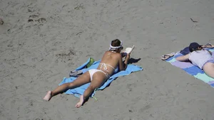 Sexy beach girl laying out in white bikini with nice body