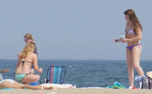 Cute girls in light blue and purple bikinis on the beach