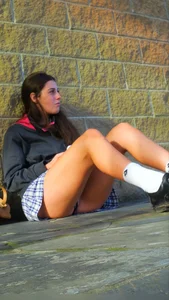 Girl Sitting on the Floor in a Skirt Revealing Panties While Standing Up