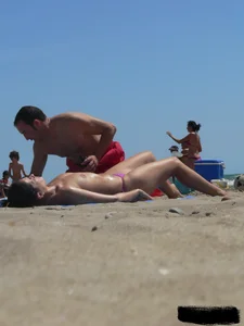 Purple thong topless lady on the beach gets oiled up by her husband
