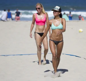 Hot girls playing beach volleyball in bikinis and shorts