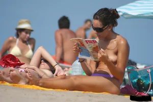 2 topless girls at the beach in thongs