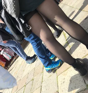 Pair of skinny legs in black pantyhose street closeup creepshot