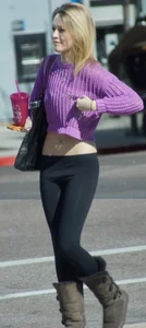 Beautiful skinny blonde in tight leggings and purple crop top showing sexy stomach