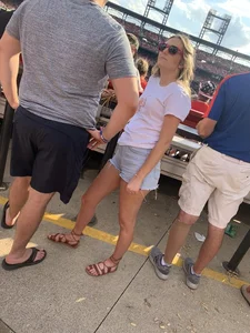 Bunch of girls in various outfits at a Cardinals baseball game