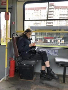 Cute teen wearing short tight jeans and boots sitting in a public bus with crossed legs creepshots