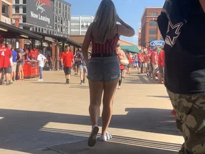 Bunch of girls in various outfits at a Cardinals baseball game