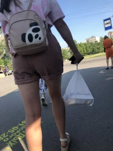 Young Girl in Sandals and Shorts in a Public Bus