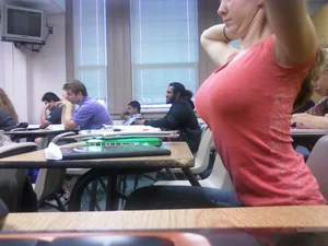 A Busty Candid College Teen Stretching Herself At Her Desk in Class