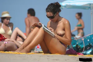 2 topless girls at the beach in thongs