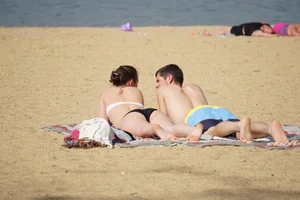 Sexy girl on the beach laying out and bending over in her bikini