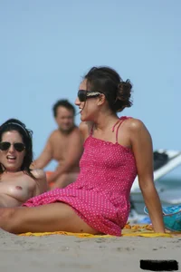 2 topless girls at the beach in thongs