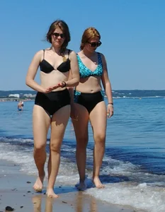 2 sexy friends in bikinis walking on the beach