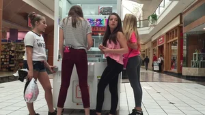 Little blonde teen in grey leggings at the mall with her friends