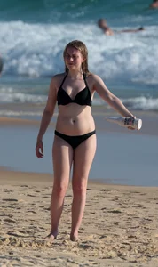 Cute bikini girl in the water in a black bikini