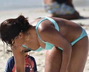 Tanned brunette girl on the beach in a bikini