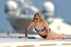 Avril Lavinge looking sexy in purple bikini on a boat