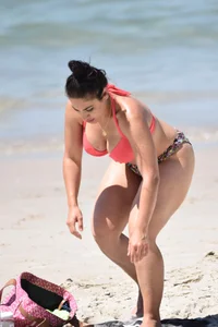 Huge boobed thick brunette babe on the beach in a bikini