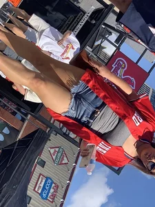 Bunch of girls in various outfits at a Cardinals baseball game