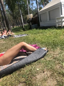 Gorgeous Skinny And Fit Girl in Red Swimsuit Lying on the Grass With a Cute Corgi