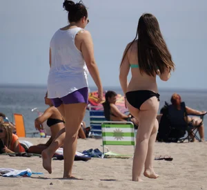 Sexy beach brunette in teal top and black bottom bikini