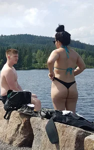 Thick brunette at the lake in a black thong bikini