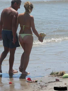 Sexy blonde on the beach in a yellow thong bikini
