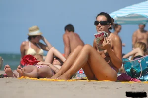 2 topless girls at the beach in thongs