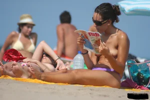 2 topless girls at the beach in thongs