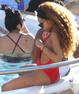 Sexy black girl in red swimsuit at the pool with side boob and a nice ass