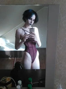 Skinny Girl with a Dark Gothic Look in a Semi-Transparent One-Piece Home Mirror Selfie