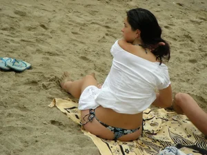 Sexy girl in a blue floral thong bikini at the beach
