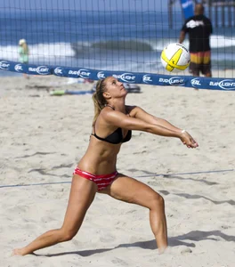Hot girls playing beach volleyball in bikinis and shorts