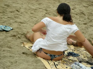 Sexy girl in a blue floral thong bikini at the beach