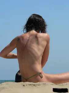 Topless beach milf looking sexy in a tiny g-string bikini
