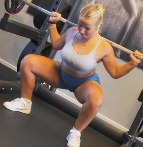 Small blonde pawg in light blue pants squatting as low as she can. Frontal view. OC