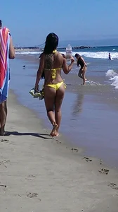 Beach babe with a nice ass and big tits in yellow thong bikini