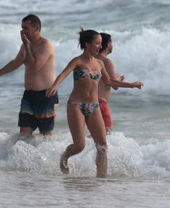 Cute skinny girl in a bikini at the beach playing in the water
