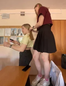 Candid college teen with nice legs, wearing a skirt, playing with her friend's hair in class