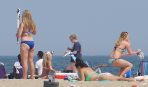 Cute girls in light blue and purple bikinis on the beach