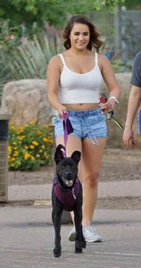 Sexy dog walker in shorts and tank top with friend in blue jeans