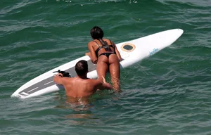Black girl on the beach in a bikini with an incredible ass while surfing
