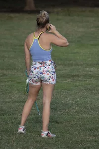 Blonde woman in tight shorts walks her dog