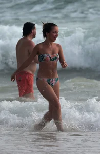 Cute skinny girl in a bikini at the beach playing in the water