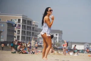 Trio of girls in bikinis on the beach and one with an incredible ass