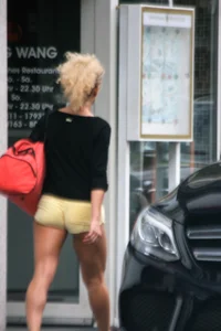 Blonde looking sexy walking in short yellow shorts