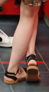 Crossed Skinny Legs of a Candid Teen Girl in Sandals Closeup Photo