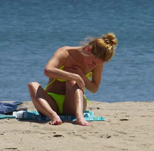 Sexy ass blonde milf on the beach in a thong with cameltoe and bending over