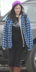 A cute brunette in leggings boots and hat
