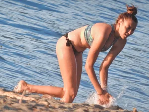 Sexy beach girl in a Nike sports bra and black bikini bottom